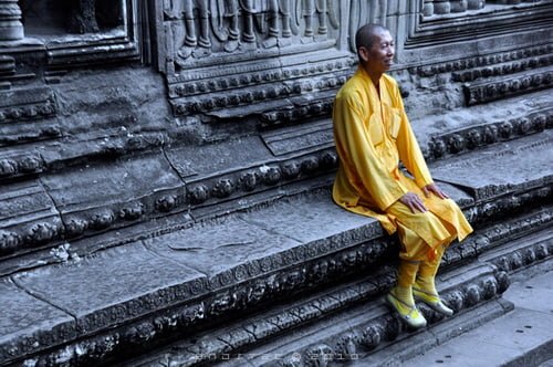 Angkor Wat was built as a Hindu temple honoring Vishnu between 1,115-1,150 AD. Cambodia adopted Buddhism in the 13th century and Buddhist monks have maintained the temple since that time.  Angkor Wat monk. © Copyright Gary Ng.