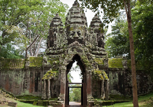 North gate of Angkor Thom, note the paired 3-headed elephants and missing pediments with the facades, thus exposing the roofing’s frame into the king’s giant faces.